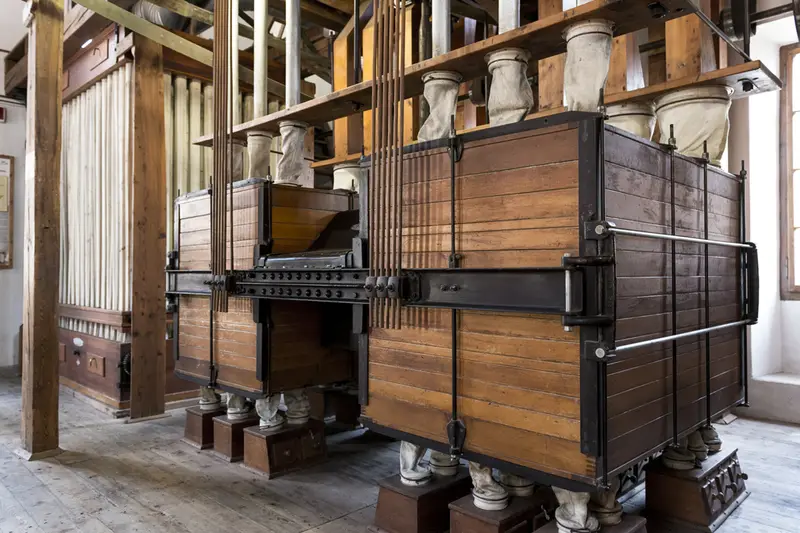 Due grandi macchine di legno del mulino, con le tramogge e i tubi del grano