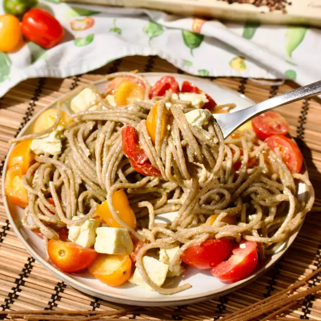 Un piatto di fidelin con grano saraceno col pesto, la feta e i datterini, e la confezione dietro