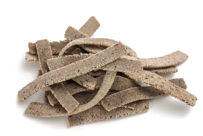 Pizzoccheri della Valtellina essiccati, le strisce brune e ruvide su fondo bianco